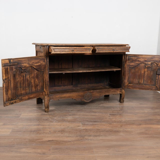 18th-century French oak sideboard featuring traditional provincial carving with floral, vine, and leaf motifs throughout....