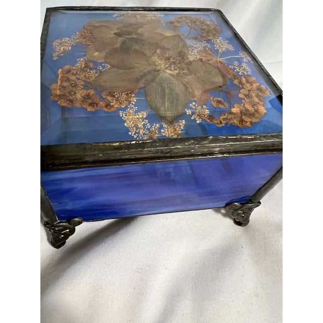 Handcrafted trinket box made of cobalt blue glass and adorned with dried flowers. This unusual piece was made by an artist...