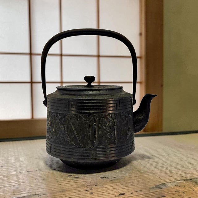 This Japanese Nambu Tekki Tetsubin by Shofudo is a traditional cast iron tea kettle with raised bamboo stalks and leaves,...