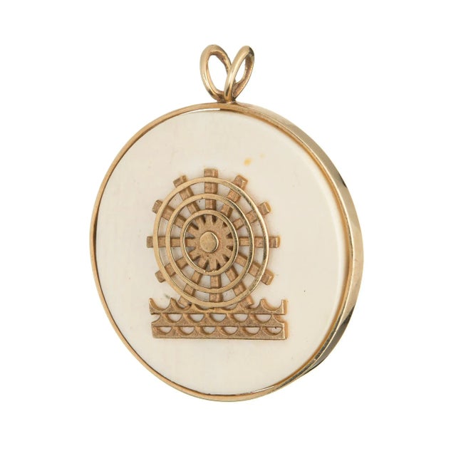 Finely detailed vintage pendant (circa 1978) crafted in 14 karat yellow gold. Off white acrylic base measures 35mm...