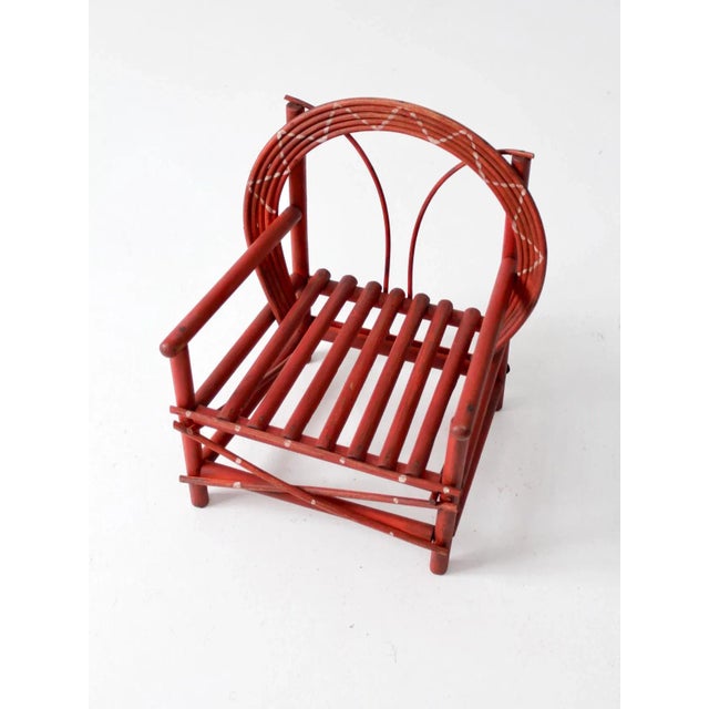 An antique Adirondack-style children’s chair with a folk art twig construction and a sculptural bentwood back. The red...