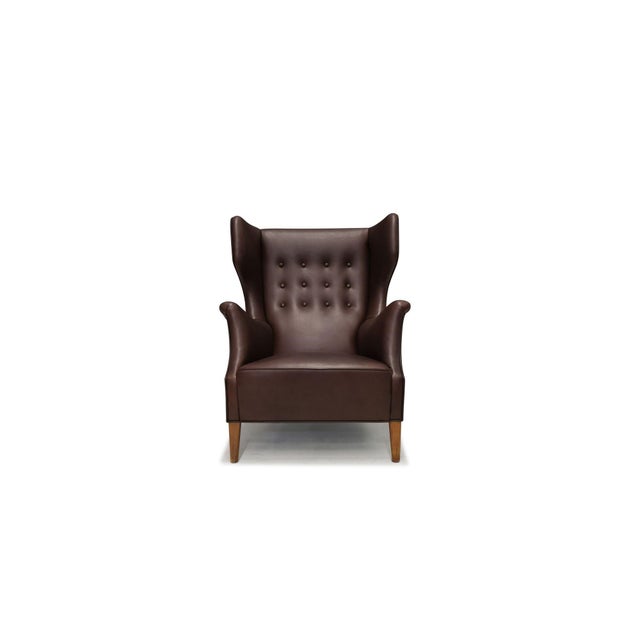 Danish wingback lounge chair, Denmark, circa 1940s. This finely crafted chair features a dramatic sculpted high back with...