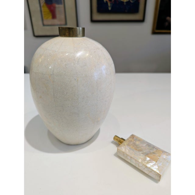 Decorative jar featuring tessellated stone body, oversized mother-of-pearl finial, and patinated brass collar. Medium...