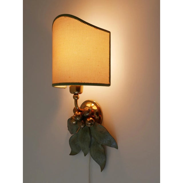 Designed and manufactured probably in Germany, 1970s. Executed in bronze patinated and partly polished brass, the sconce...