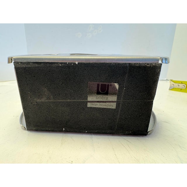 Sculptural stainless steel napkin holder designed by Dennis Cheng for Umbra, featuring a refined cut-out leaf motif in...