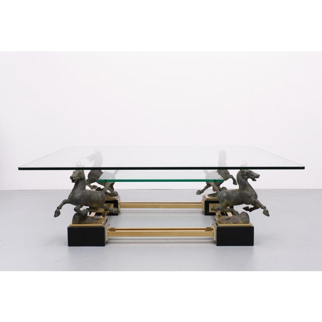 A beautiful square coffee table by Maison Charles from the 1970s. A stylish coffee table, with 4 bronze horses "flying...