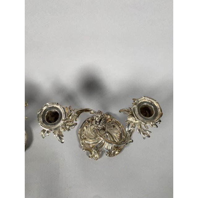 Pair of Rococo Style Silvered Bronze Candelabra, 19th Century. A pair of Rococo style candlesticks in chased and silvered...