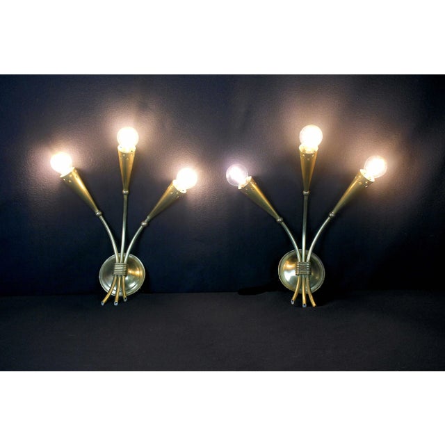Elegant full brass pair of sconces with wonderfull details such as stars cut on the brass metal. Produced during the...