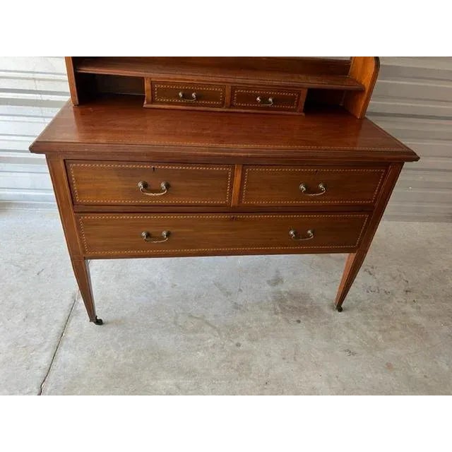 This vanity table in mahogany veneer, circa late 19th century. This piece of furniture is of a simple form, placed on...