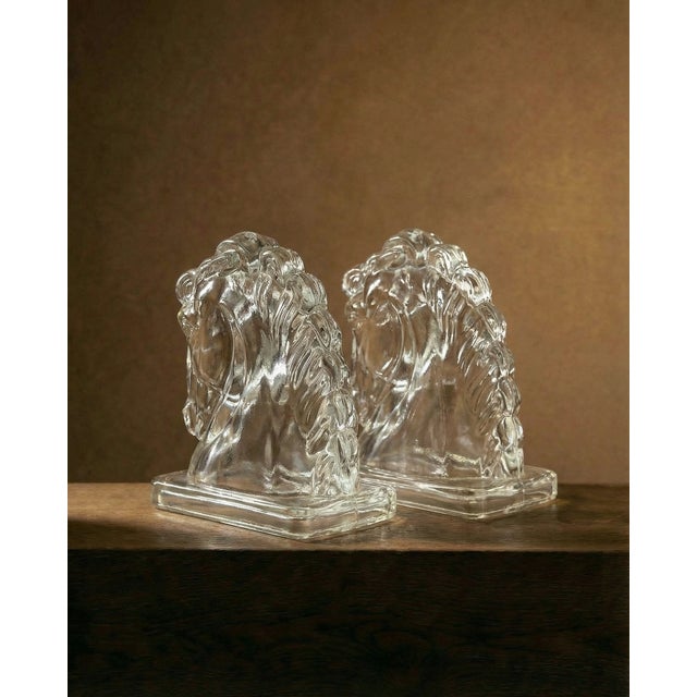 Elegant glass horse head bookends bring sculptural style to your shelves. Crafted from clear glass with a hollow interior,...