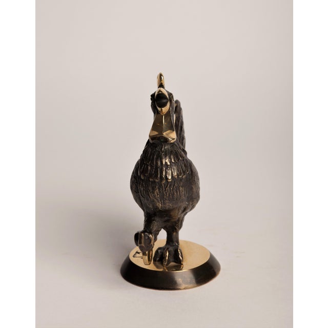 An Art Deco–style animal bronze of a rooster mid-crow, head thrown back, beak open, one leg lifted as if stepping forward...
