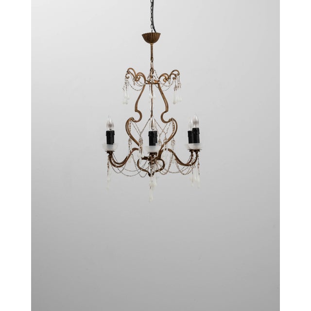This 20th Century Italian Rococo Revival gilt metal chandelier captures the ornate elegance and expressive curves...