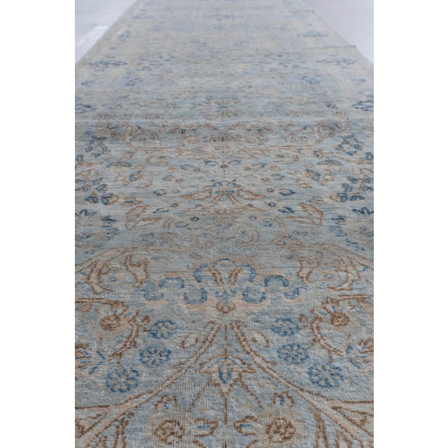 This oversized antique Kirman runner was woven in the southern Persian town of Kirman. Bountiful floral patterns woven in...