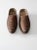 This is a pair of antique wooden clogs, hand-carved with decorative patterns across the feet. The warm patina and...