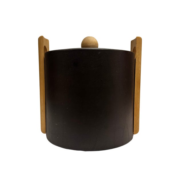 A stylish mid-century modern ice bucket designed by George Briard, featuring a black leatherette-wrapped cylindrical body...