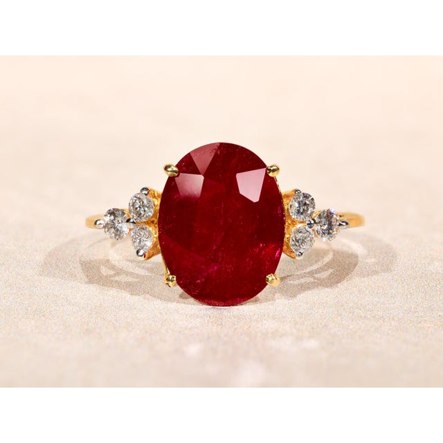 The Allyns Alley Ladies 18K Yellow Gold Ring set with 3.44 CT Oval Ruby and Diamonds. Crafted in 18 karat yellow gold,...