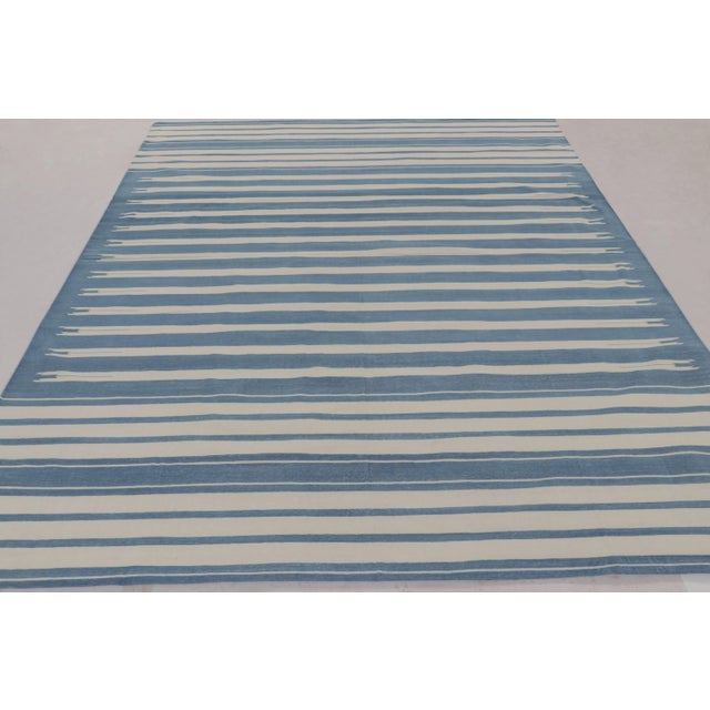 This 8x10 Dhurrie rug features horizontal stripes in white and blue, representing an exciting cont emporary flatweave...