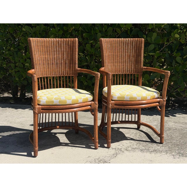 Exceptional vintage pair of barrel-back rattan dining armchairs with beautifully crafted curved frames and intricately...