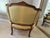 Elegant vintage Louis XV style bergère chair featuring a beautifully carved wood frame, cabriole legs, and tufted...