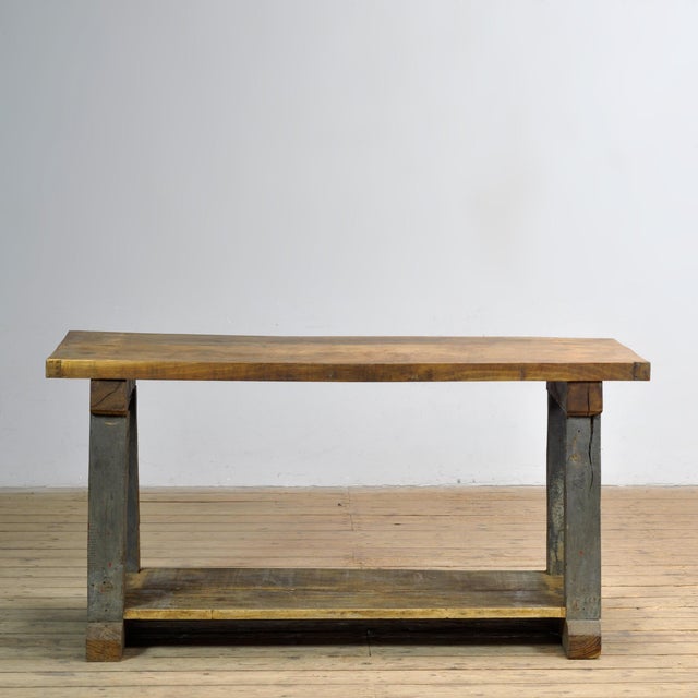 This robust industrial work table, crafted from solid oak and dating from circa 1950, combines functionality with an...