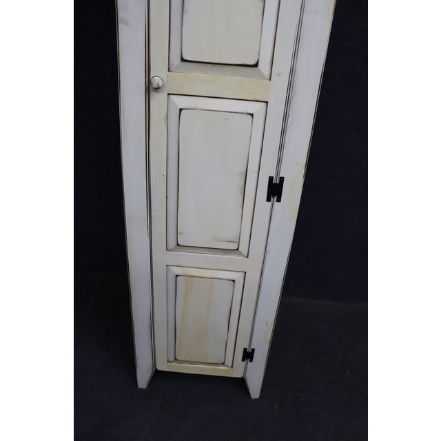 Charming tall and narrow painted pine chimney cupboard with a classic country form. The cupboard features a paneled door...