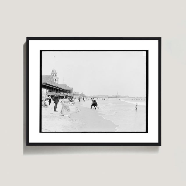 This scene from turn-of-the-century Narragansett Rhode Island features a charming scene of Victorian beach goers. Printed...