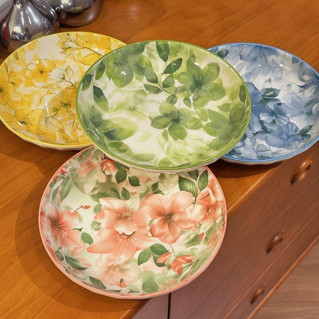 This is a set of four ceramic plates featuring exquisite floral patterns. These plates are a wonderful way to add color...