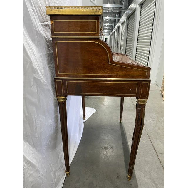An elegant French 19th Century Louis the XVI Mahogany, brass, ormolu, marble, cylinder desk. The desk has cylinder,...