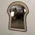 This is a postmodern keyhole-shaped tessellated travertine and marble mirror by Diamond Mission, made in the Philippines....
