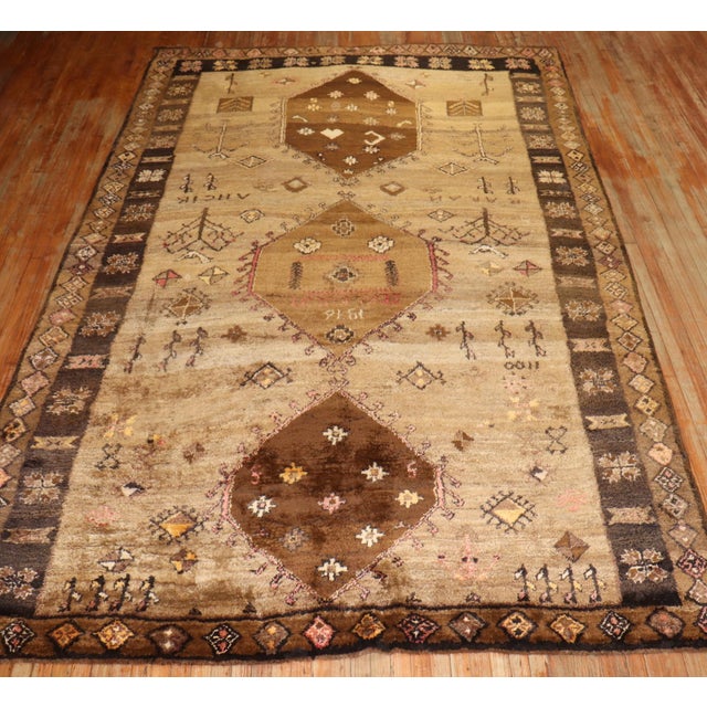 A thick pile tribal Turkish Kars Rug with a large-scale geometric design on a brown field dated 1976.