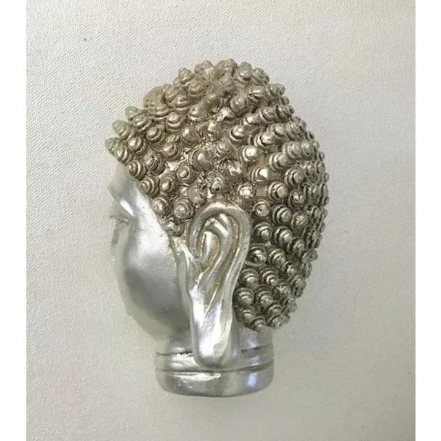 Add a peaceful accent to your home or garden with this enchanting small Buddha Head resin sculpture with a soft silver...