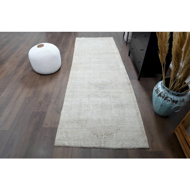 Vintage Hand-Knotted runner rug is a semi-antique vintage beige runner rug. The '70s Eastern region of Anatolian's unique...
