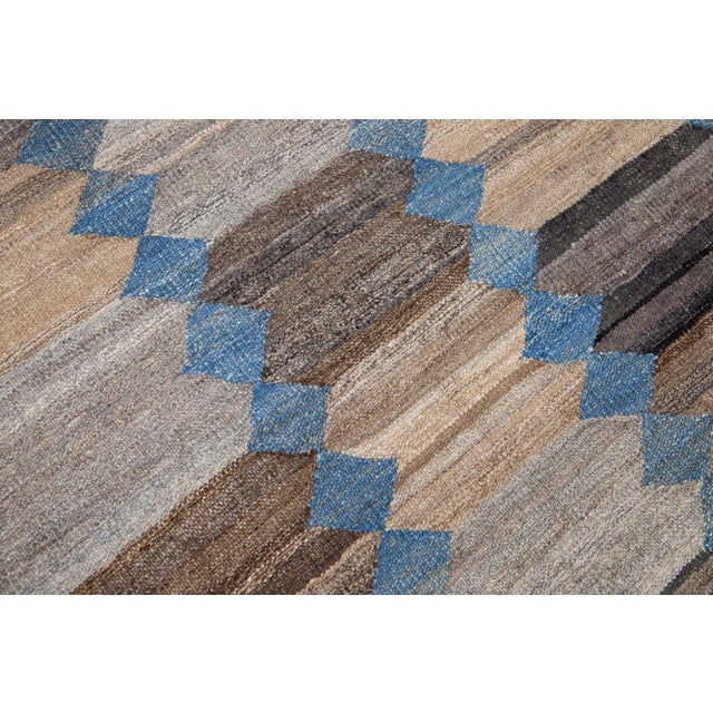 This Deco flatweave wool runner exhibits a captivating blue field with brown and beige accents, creating a contemporary...