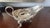 Elegant vintage Godinger silver-plated gravy boat featuring an ornate floral and scroll border with decorative feet and a...