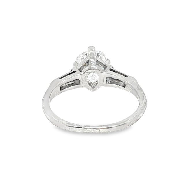 A mid-century platinum engagement ring featuring a pear-cut white diamond. The primary stone is approximately 1.0 carat,...