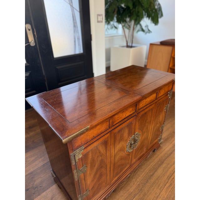 An exceptional Henredon Scene One Collection Slide-top dry bar cabinet, masterfully crafted in richly figured mahogany and...