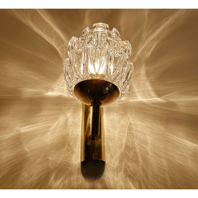 Pair of Vintage sconces from the 1960s with stylised flame shaped crystal glass shades mounted on an brass structure...