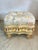 This footstool has a charming, vintage elegance with strong Rococo or French Provincial influences. Here’s a detailed...