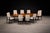 A sculptural and well-proportioned set of eight dining chairs by Cimo, Brazil, circa 1950 — executed in ebonized hardwood...