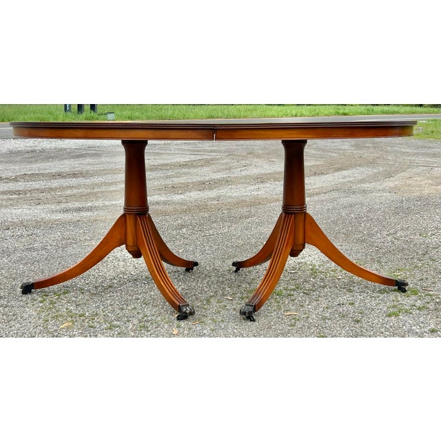 Duncan Phyfe / Regency style oval extension dining table. Double pedestal base with reeded legs and turned central...
