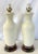 Timeless pair of creamy white ceramic lamps from the mid 20th century. They are made of white ceramic and sit on wood...