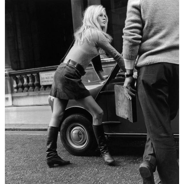 Mini Car Mini Skirt Brigitte Bardot during a break from filming, 'Two Weeks in September' in Whitehall, London. Leaning...