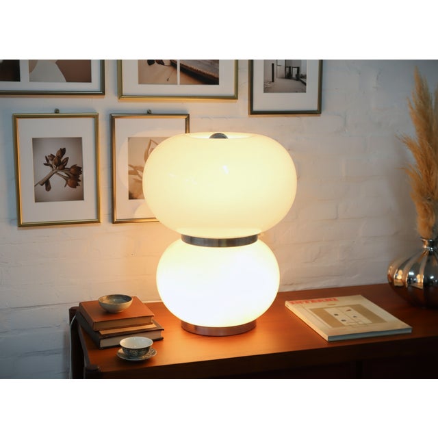 Illuminate your space with a touch of authentic Italian design. This exquisite table lamp, a genuine late 1960s creation...