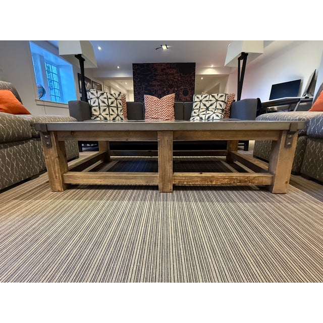 Elevate your space with this contemporary coffee table, featuring a solid gray stone top paired with a warm wood leg base...