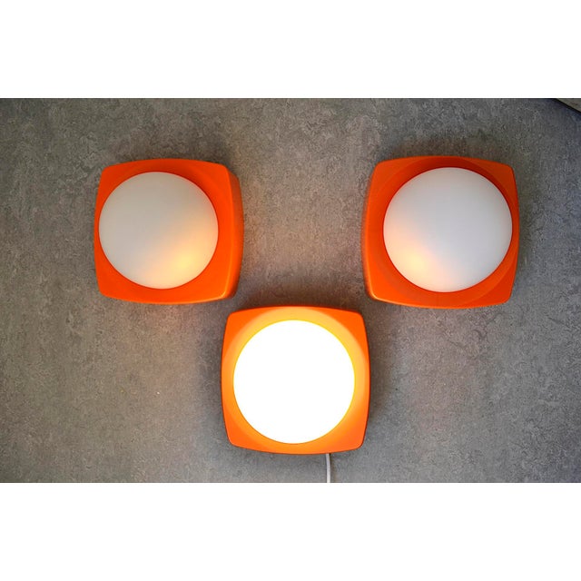 1970s wall or ceiling lights from the Dutch lighting company Herda. The lights are made of orange hard plastic, possibly...