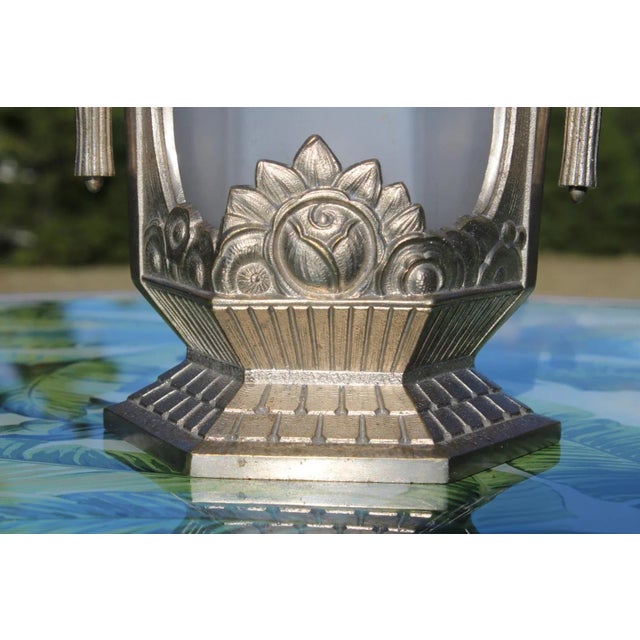 The base of this French Art Deco lamp is nickel-plated bronze and features stylized flower motifs that were so popular...
