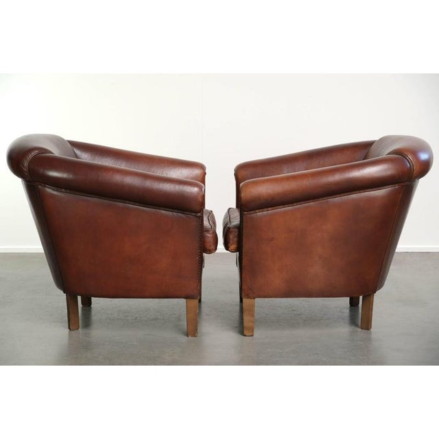 This set of 2 sheepskin club armchairs in a dark cognac color finished with decorative nails. : This set of 2 sheepskin...