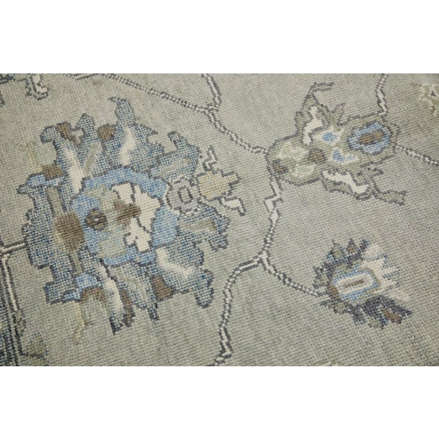 This modern Turkish Oushak rug is a stunning piece of art that has been handwoven using traditional techniques by skilled...