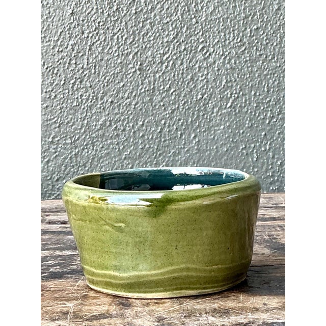 This vintage handcrafted studio pottery bowl is a refined example of mid-20th-century artisanal ceramic work,...