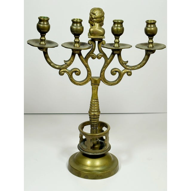 This striking antique brass candelabrum offers both architectural presence and symbolic depth. The central column anchors...